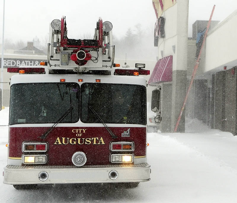 An Augusta ladder truck sits in front of Turnpike Mall as an Augusta fuel technician climbs onto the roof to check the heating system around 3:20 p.m. on Saturday Feb,. 9, 2013 in Augusta. The fire department found high carbon-monoxide levels in the front of the building.