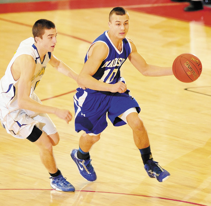 Boothbay's John Hepburn, left, defends Madison's Dylan Price during a Western Class C boys' basketball semifinal Thursday at the Augusta Civic Center. Boothbay broke away from a 35-35 tie to earn a 55-41 victory.