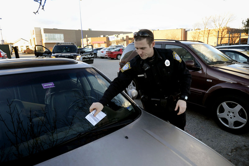 South Portland Police Officer Kevin Sager writes tickets to illegally parked cars at the Maine Mall on Thursday, Jan. 31, 2013.