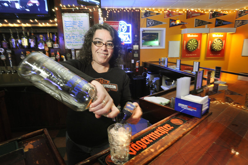 Bartender Laurie Lavertu mixes a drink at The Frosty Pint in Portland. The bar is owned by a veteran whose dream was to open a sports bar reminiscent of the famed sitcom bar Cheers.
