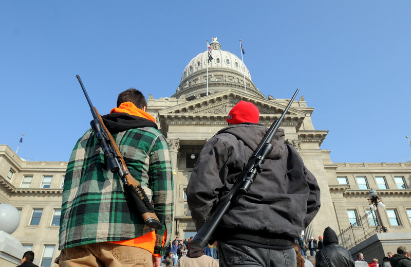 Chance Novak, 18, left, and his father, Chet, both of Boise, stand outside the Idaho Statehouse in Boise after a pro-gun rally Jan. 19, as part of Gun Appreciation Day events held around the country.