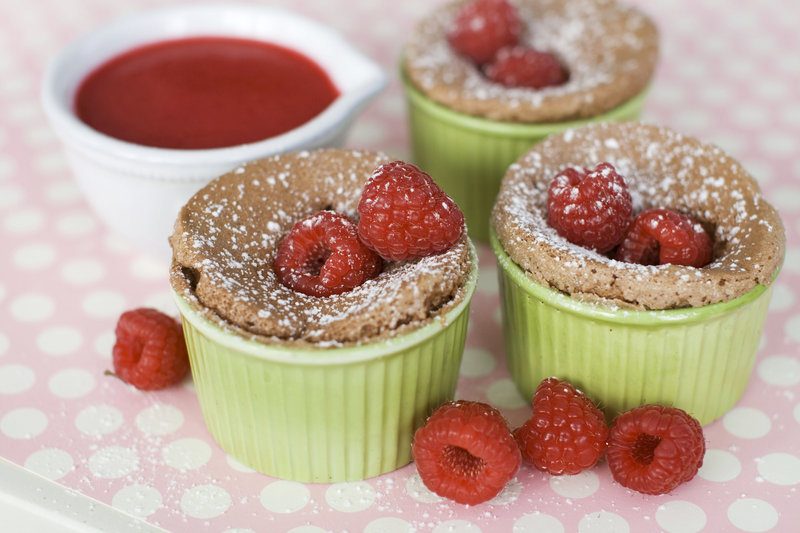 Warm chocolate cakes with raspberry sauce are individual sized and filled with ooey-gooey deliciousness.