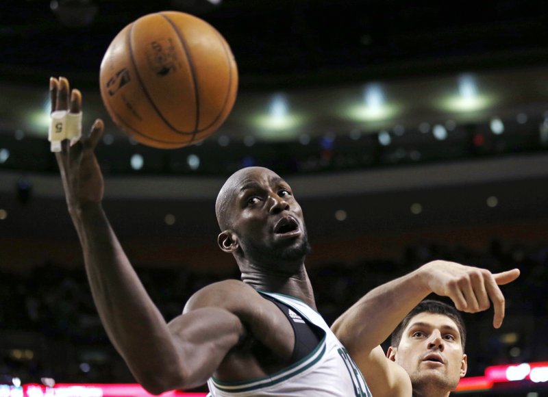 Kevin Garnett of the Boston Celtics reaches the ball ahead of Nikola Vucevic of the Orlando Magic during the second half of the Celtics’ 97-84 victory at home Friday night.