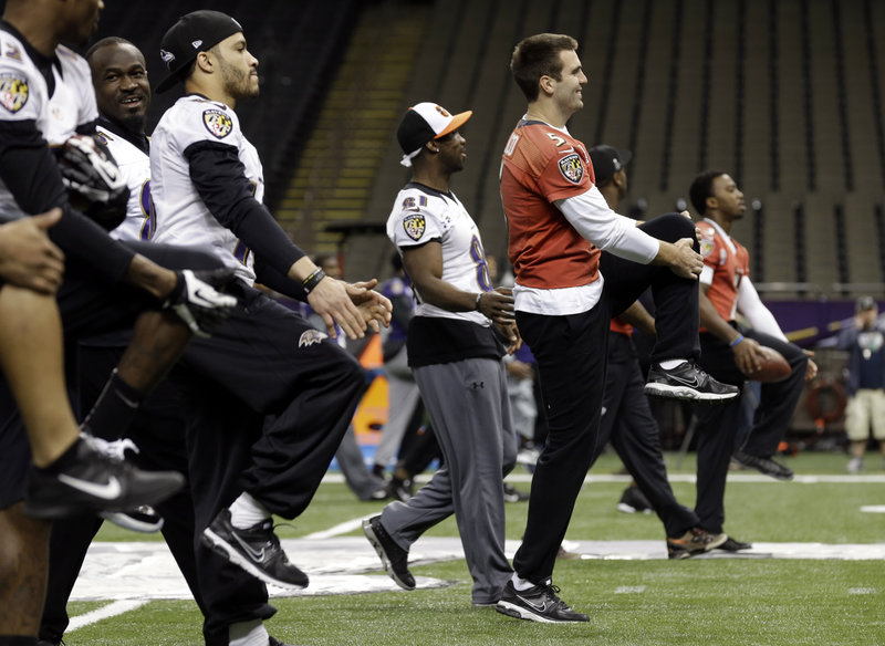 Joe Flacco, right, and his Baltimore Raven teammates warm up Saturday at the Superdome during a walkthrough for the Super Bowl against the San Francisco 49ers.