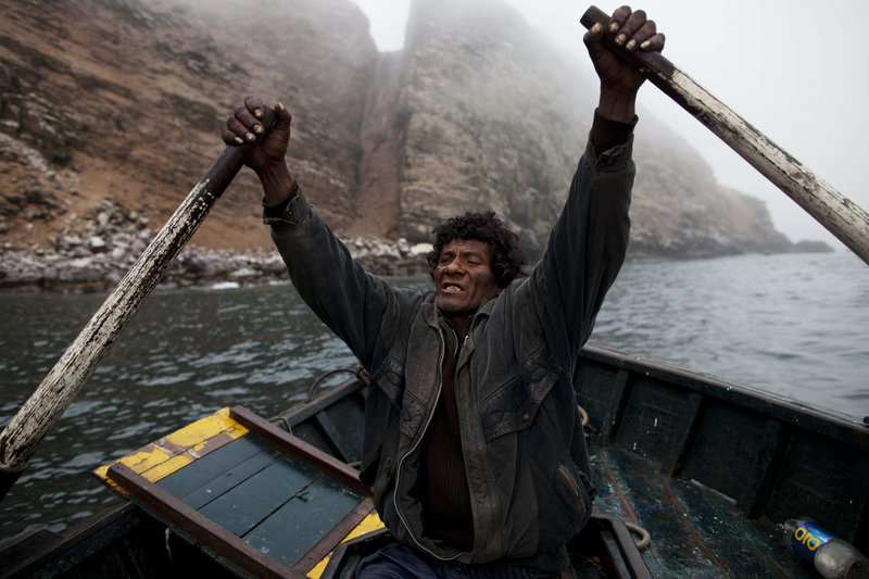 Alvaro rows a small boat as he goes fishing for the depleted anchovy in the Pacific off the coast of Peru.