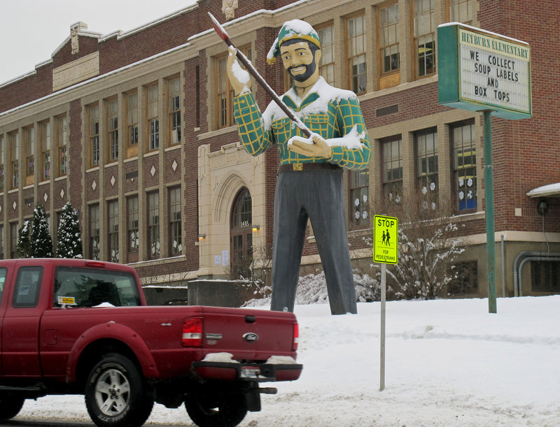 A statue of a logger stands outside a school in St. Maries, Idaho, near where a survivalist compound is planned.