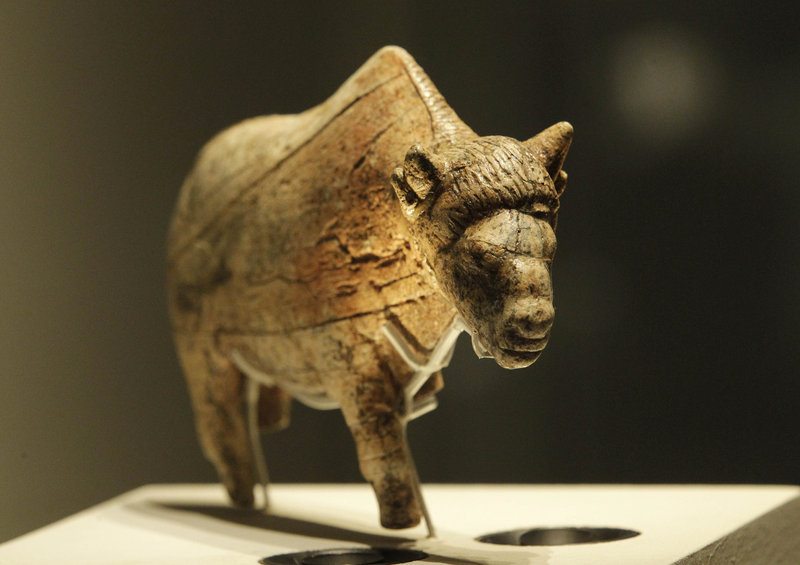 Artifacts on display include a sculpture of a bison worked from a piece of mammoth tusk that is at least 21,000 years old, and the oldest known portrait of a woman, also sculpted from mammoth ivory, that is at least 27,000 old.