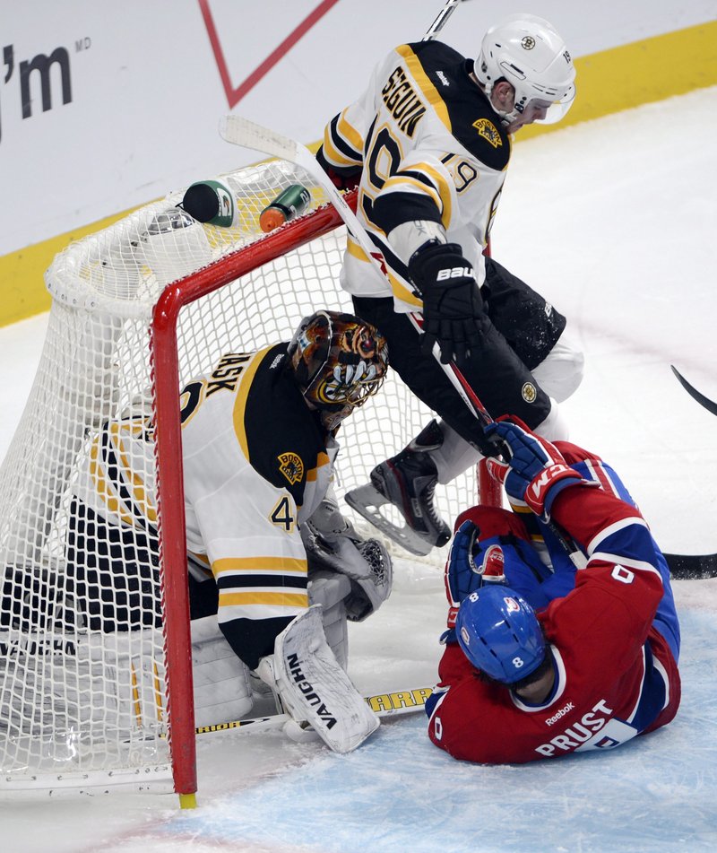 Brandon Prust of the Canadiens slides into Boston’s Tyler Seguin and goalie Tuukka Rask Wednesday night.
