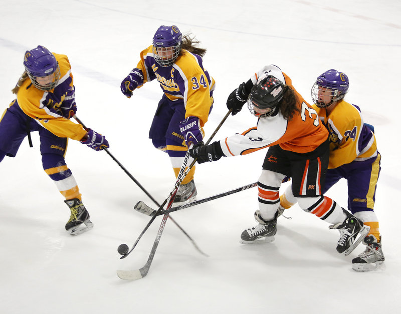 Cheverus defenders Kate Brewer, left, Katie Roy and Paige Severance, right, converge on Brea Rivard of Biddeford during the second period of Cheverus’ 7-4 victory in a Western Maine quarterfinal Wednesday night.