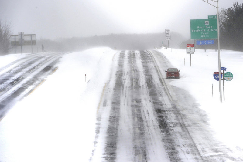 An abandoned vehicle sits on the side of the southbound lane of the Maine Turnpike in Portland on Saturday. Officials discouraged travel on the highway during the 2013 Blizzard that hit Maine.