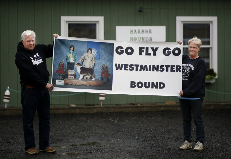 Vern Clark and his wife, Clara Gardner, hold a poster for their Australian shepherd Fly at their kennel in Rockland.