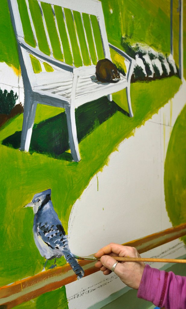 Artist Francine Schrock paints a blue jay on a section of her mural.