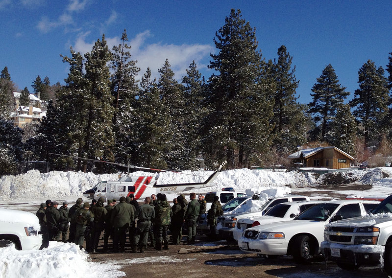 Law enforcement officials gather Saturday near Big Bear, Calif., to discuss the search for Christopher Dorner, suspected in the slayings of those he blamed for ending his police career.