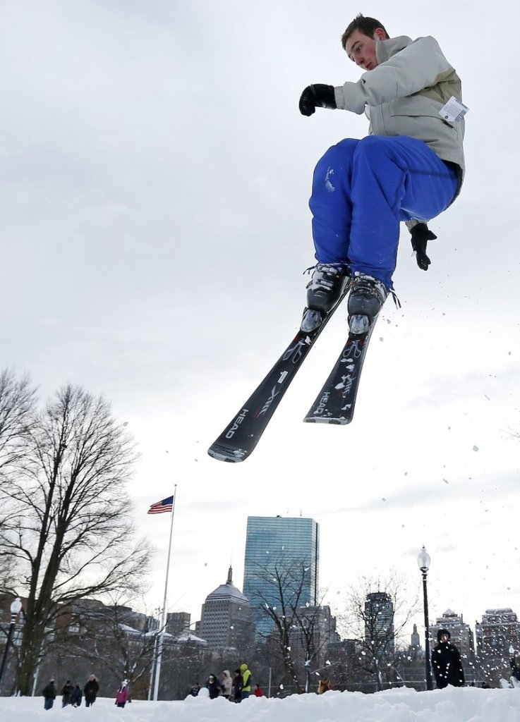 Thomas Kolek, a Northeastern University student from Westford, Mass., spins a helicopter jump while skiing on Boston Common in Boston on Saturday. The Boston area got about 2 feet of snow.
