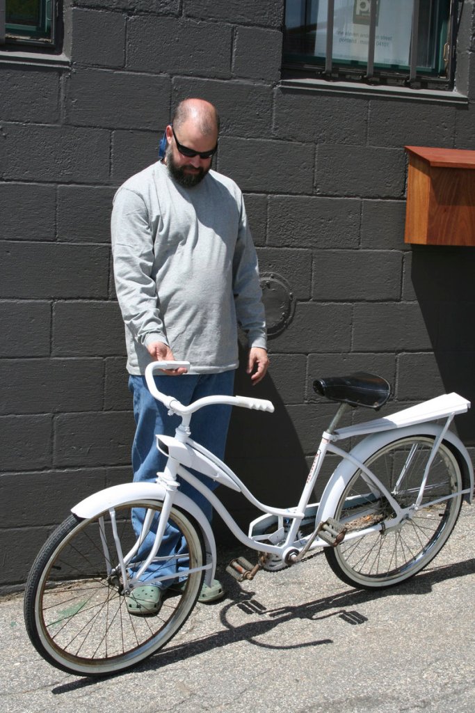 John Rooks shows one of eight bicycles used in an ad-hoc bike-sharing program he ran for two years in Portland.