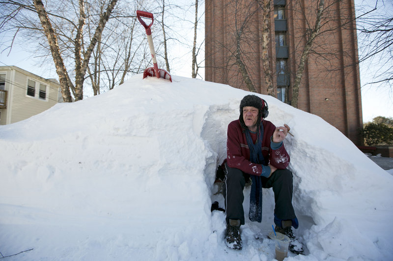 Bert Johnson takes a break while clearing snow from a bus-stop bench outside the apartment complex where he lives.