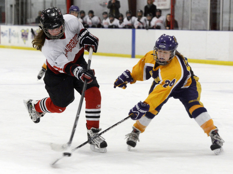 Scarborough’s Kristen Murray fires the puck despite obstruction from Cheverus defender Paige Severance during Monday’s Western Class A semifinal game in Saco, won by the Red Storm, 6-1.