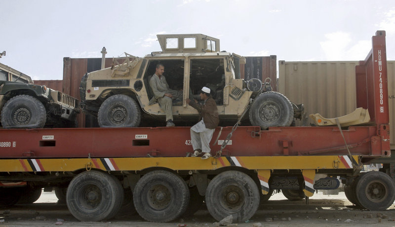Pakistani driver assistants talk while sitting on a truck carrying NATO Humvees at a terminal on the Afghan border in Chaman, Pakistan, on Monday. The U.S. has started using the land route through Pakistan to pull military equipment out of Afghanistan.