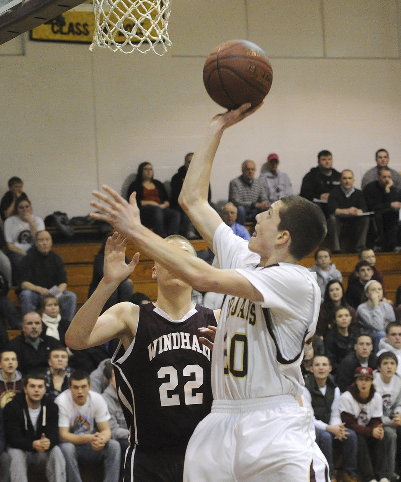 Evan Wright of Thornton Academy finds room inside Tuesday night to shoot while guarded by Dylan Weisser of Windham.