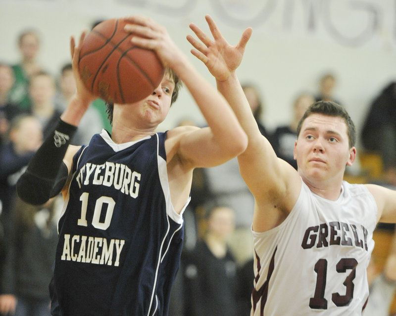Fryeburg’s Jonathan Burk pulls in a rebound against Greely’s Bailey Train during Tuesday night’s game in Cumberland, won by Greely.
