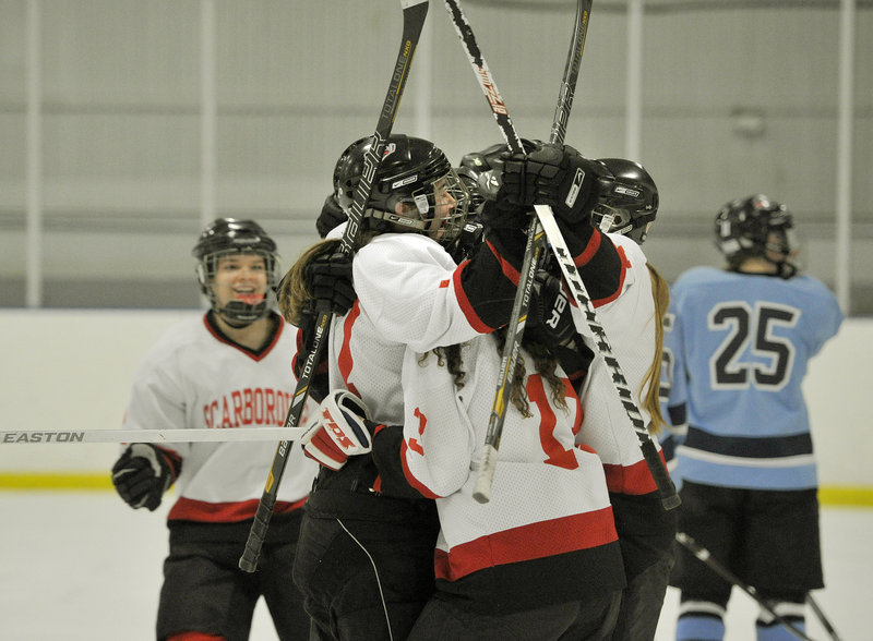 Sarah Martens is surrounded by teammates after scoring the second-period goal that stood up as the winner for Scarborough.