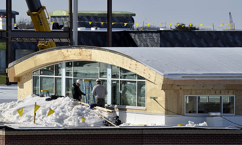 Workers add trim to the windows of the new cafeteria added to the roof of an original building as part of an expansion and renovation of South Portland High School. Photographed on Thursday, Feb. 14, 2013.