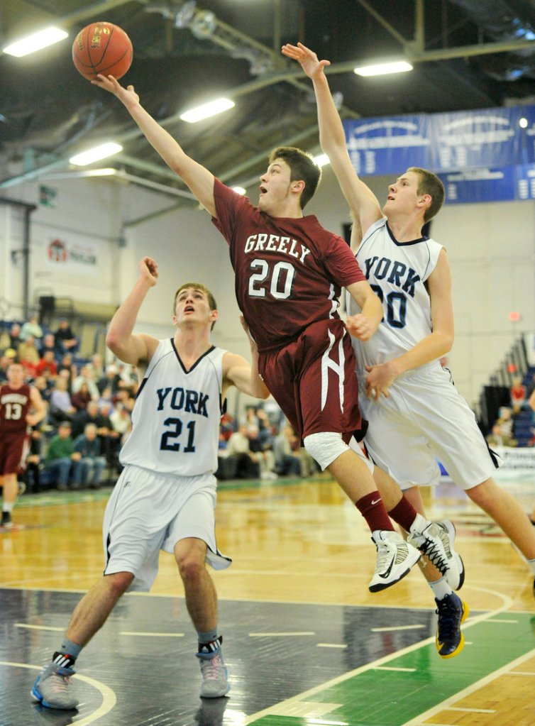 Jonah Normandeau of Greely scoops the ball toward the basket past Aaron Todd, left, and Adam Bailey of York during York's 64-38 victory in a Class B quarterfinal at the Expo.