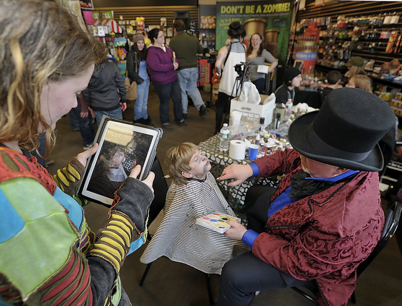 Dezzmon Clark, 5, gets a zombie makeover by Reggie Groff as his mom, Terri Wengland of Standish, takes an iPad photo.