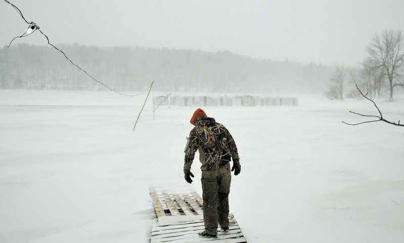 Jordan Mayo heads out to clean camps at Sonny’s Smelt Fishing on the frozen Kennebec River in Dresden on Sunday. Winds gusted to 30 mph and blowing snow limited visibility to less than 100 yards.