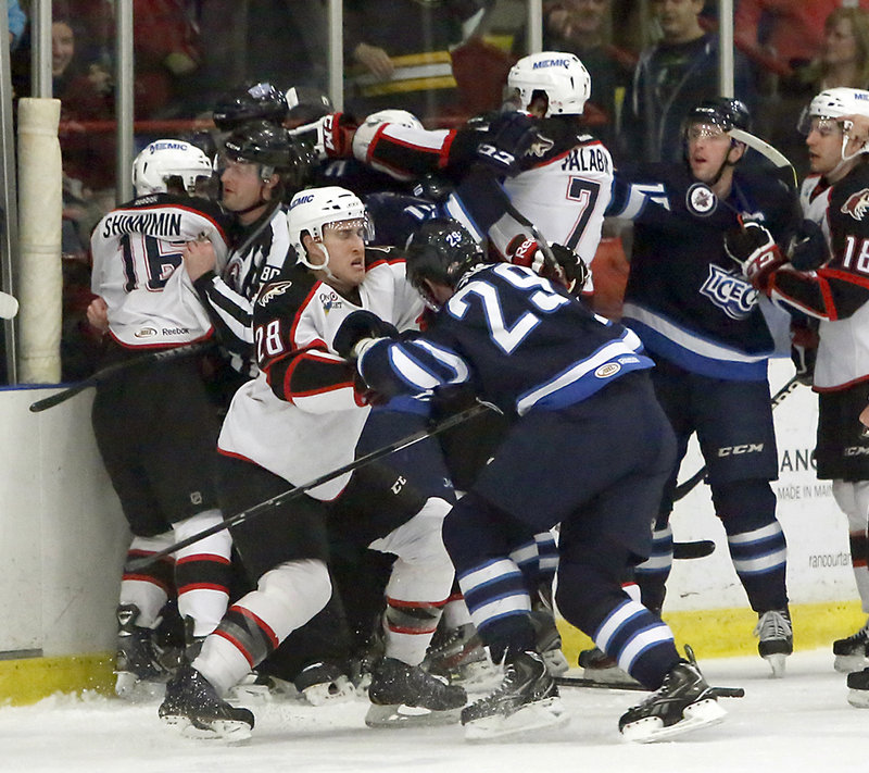 The referee earns his keep Sunday afternoon at the Androscoggin Bank Colisee in Lewiston, separating combatants during a first-period scrum between the Portland Pirates and the St. John’s IceCaps.