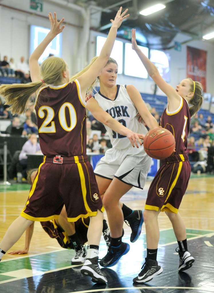 Emily Campbell of York passes to a teammate after driving the lane against Cape Elizabeth defenders, including Hannah Sawyer, 20. York won 47-39 to reach the Western Class B semifinals.