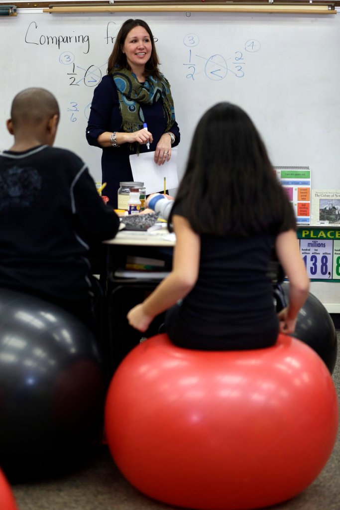 Robbi Giuliano teaches her fifth graders as they use their muscles to balance on yoga balls, a practice that increases blood flow, leading to more alertness.