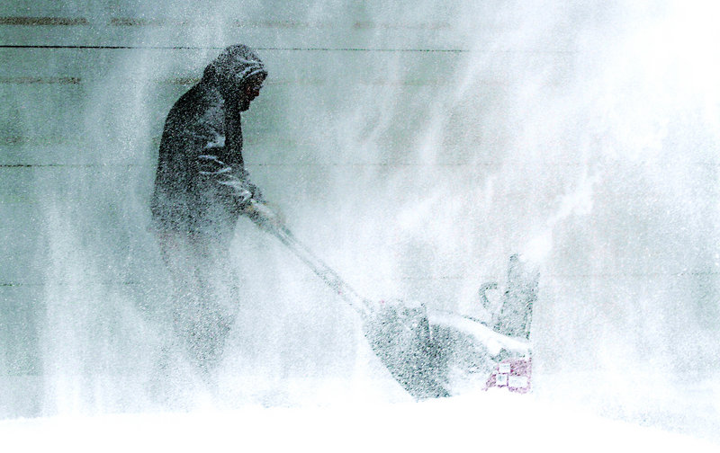 Tom McReynolds clears snow from a neighbor’s house in Wichita, Kan., on Thursday. Kansas was the epicenter of the winter storm, with parts of Wichita buried under 13 inches.