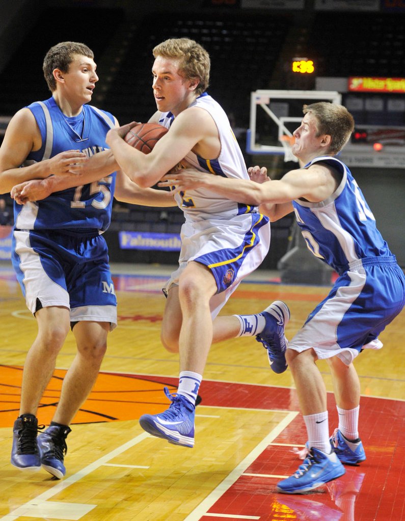 Tom Wilberg of Falmouth protects the ball Thursday night from Dominic Haines, left, and Adam Volkernick of Mountain Valley in their Western Class B semifinal at the Cumberland County Civic Center. Falmouth won, 58-22.
