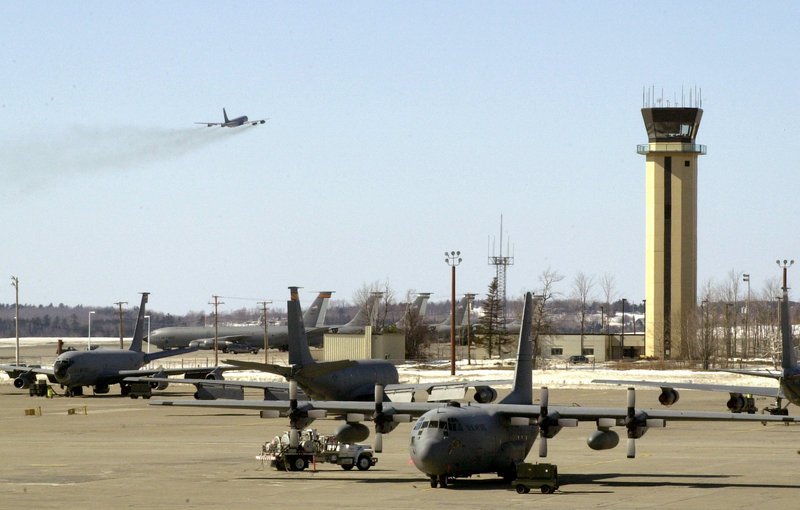 A KC-135 refueling tanker takes off at Bangor International Airport in 2003 as other refueling planes and transport planes sit below the airport control tower.