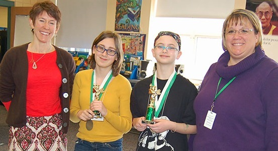 Bonny Eagle Middle School Spelling Bee moderator Ethel Atkinson, left, poses with runner-up Annabel Winterberg, winner Emma Whelchel and bee mistress Krista Poulin.
