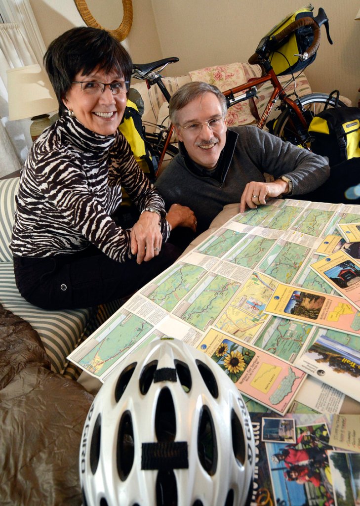 Debbie and Tim Bishop, at their home in Marlborough, Mass., show some of the maps they used on their honeymoon bicycle trip from Seaside, Ore., to Cape Elizabeth, Maine.