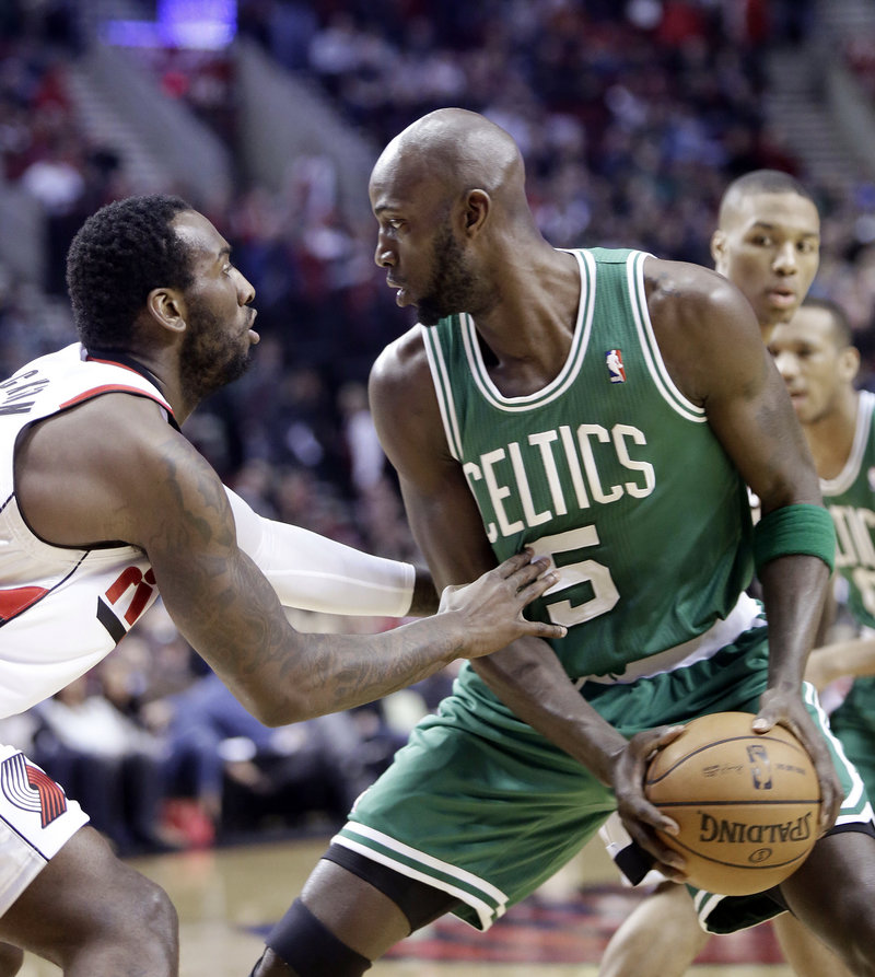 Boston forward Kevin Garnett looks for an opening against Portland center J.J. Hickson during first-quarter action of Sunday’s game, won by the Trail Blazers.