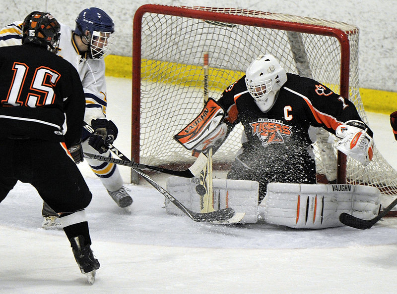Biddeford goalie Jon Fields keeps his focus and denies Billy Mullin of Falmouth on a rebound as Wyatt Leblond helps to defend. Falmouth improved to 15-3-1 and outshot the Tigers, 46-14.
