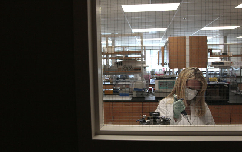 An investigator extracts DNA from a sample at the State of California Department of Justice Laboratory in Richmond, Calif.