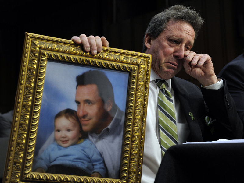 Neil Heslin, father of a Sandy Hook victim, holds a picture of himself with his late son Jesse while testifying on Capitol Hill Wednesday in favor of an assault weapons ban.