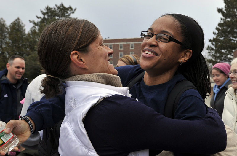 UMaine assistant coach Jhasmin Player, right, receives a hug from former director of basketball operations Tracey Guerette, as the women's basketball team returned to Orono on Wednesday evening, Feb. 27, 2013, after being involved in a harrowing crash on I-95 in Massachusetts on Tuesday night.