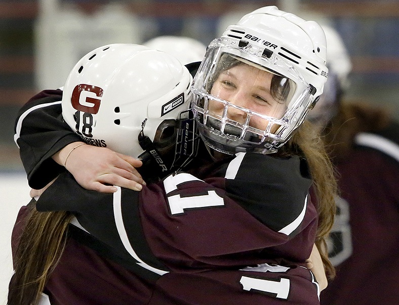 Mary Morrison, right, hugs Chesley Andrews after scoring the overtime goal Saturday night that gave Greely its second straight girls’ hockey state championship with a 1-0 victory against Scarborough at Lewiston.