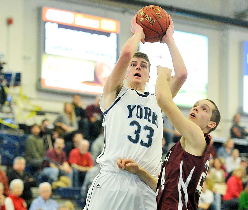 Hayden Webster of York puts up a shot over Greely's Connor Hanley in Saturday's Western Class B boys' basketball quarterfinal at the Portland Expo. Webster scored 13 points in York's 64-38 win.