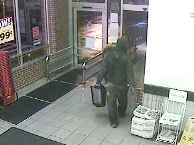 Surveillance photo of suspect leaving the Hannaford store carrying a plastic trashcan.