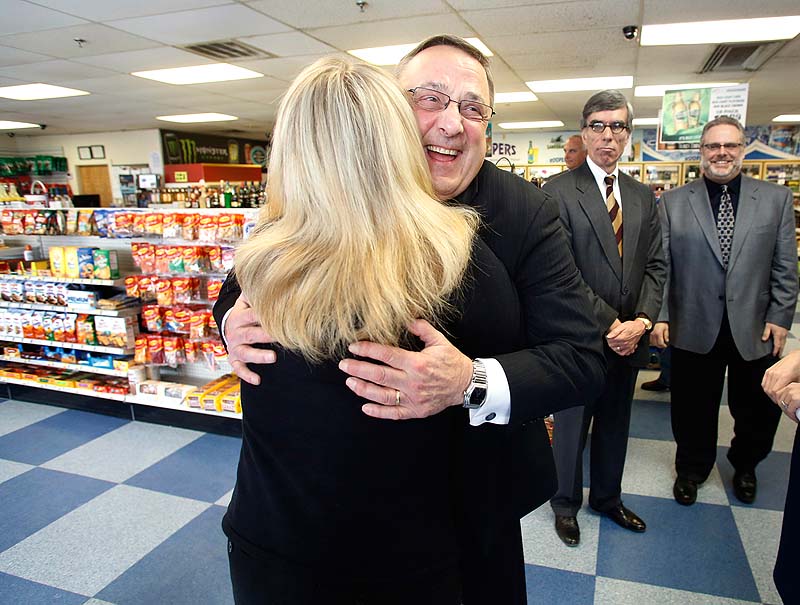 Gov. Paul LePage hugs supporter Laurie Steele after speaking to the media during his visit to Roopers Beverage in Auburn on Friday.