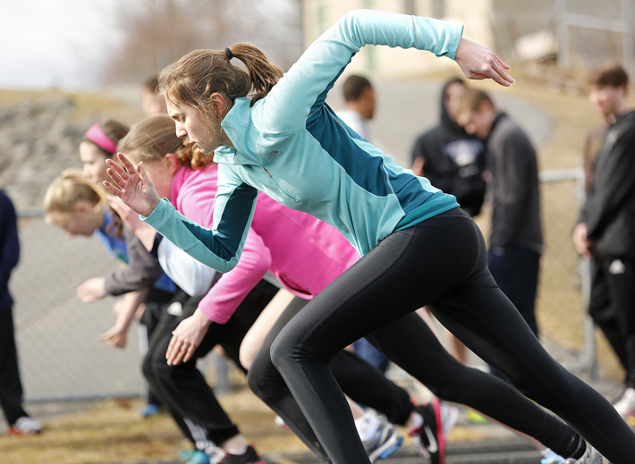 Freshman Sarah Mount and other track team members work on starts at Cheverus High School on Monday, the first day of practice for full spring sports teams.
