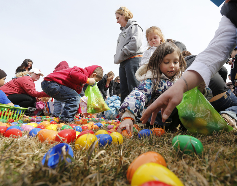 Courtney Lane-Hebert of Lisbon watches as her son Mason Hebert, 3, collects eggs. At right, Morgan McLaskey, 6, of Westbrook fills her bag.