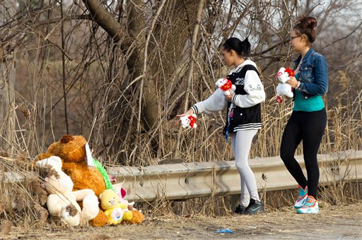 Dominique Ellison, left, and Rickie Bowling, of Warren, bring stuffed animals to a memorial in honor of their friends who died in a car crash on Park Ave. in Warren, Ohio on Sunday, March 10, 2013. (AP Photo/Scott R. Galvin)