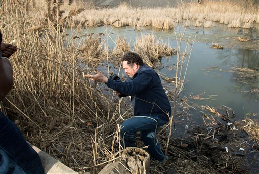 Beduareo Marquez climbs up the pond embankment where he retrieved a shoe from the crash site that six teens died on Park Ave. in Warren, Ohio on Sunday, March 10, 2013. (AP Photo/Scott R. Galvin)